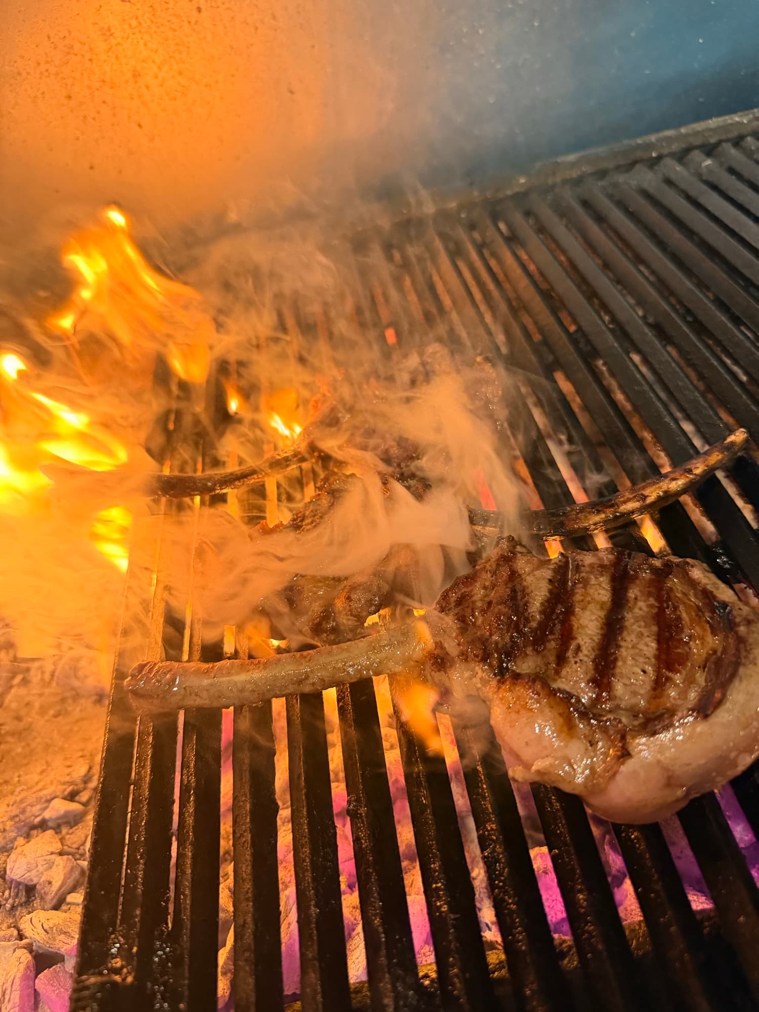 Tomahawk steak over open flame on the charcoal grill