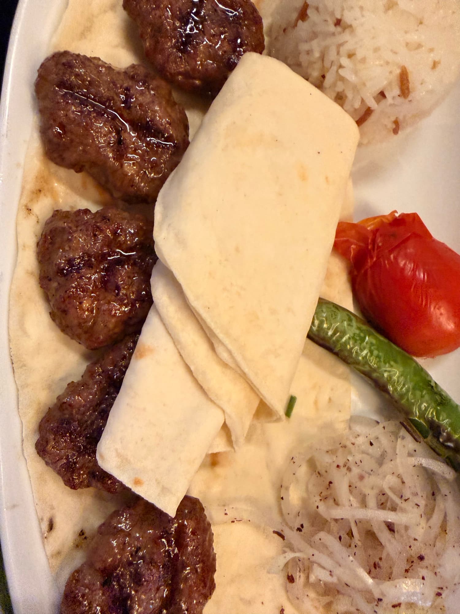 Grilled köfte with lavash, roasted tomato and green pepper