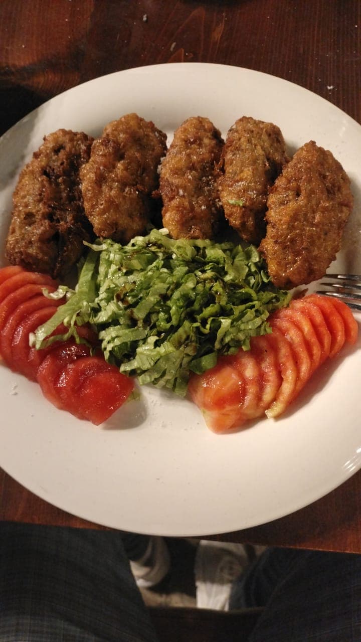 Köfte with rocket and sliced tomato